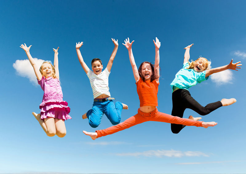springende Kinder vor einem blauen Himmel